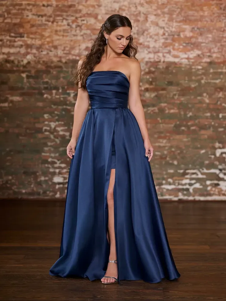 A woman is wearing a blue strapless dress with a high slit.