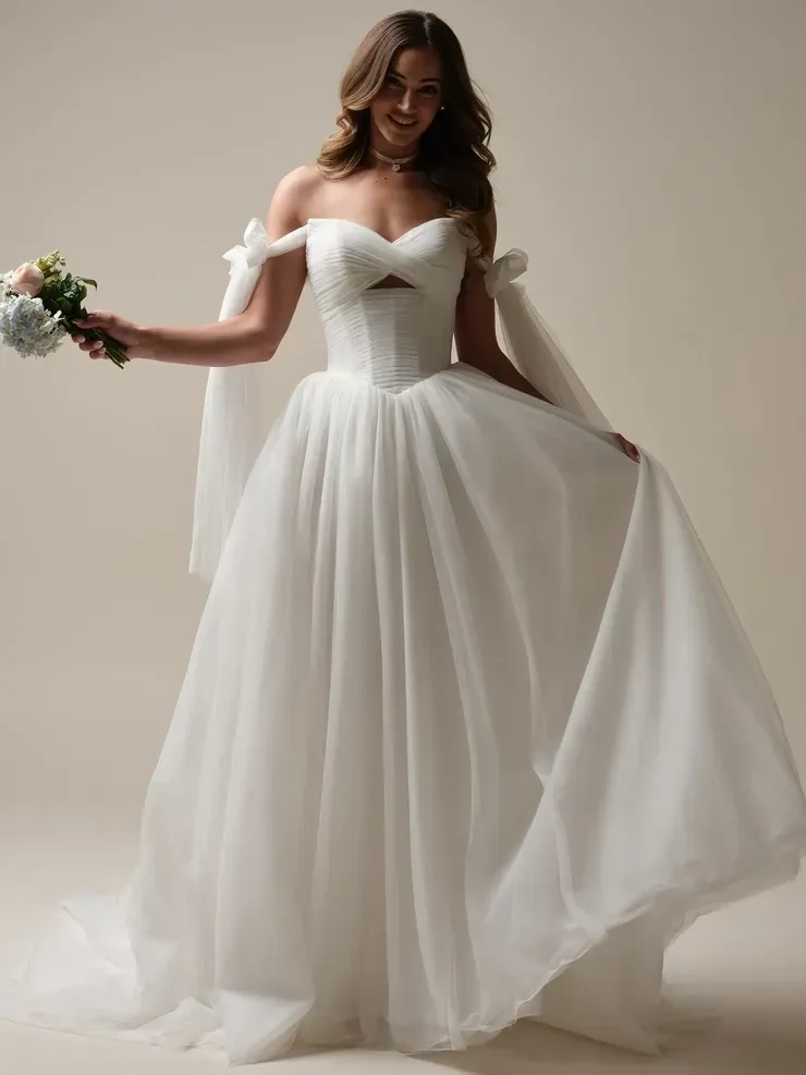 A woman in a white wedding dress is holding a bouquet of flowers.