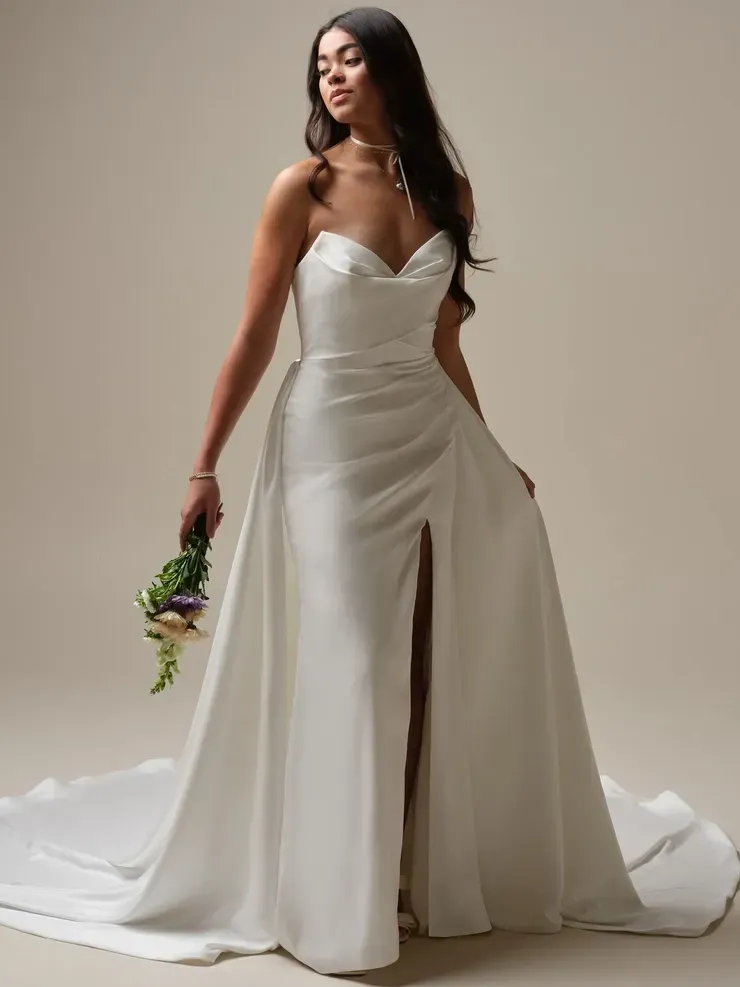 A woman in a white wedding dress is holding a bouquet of flowers.