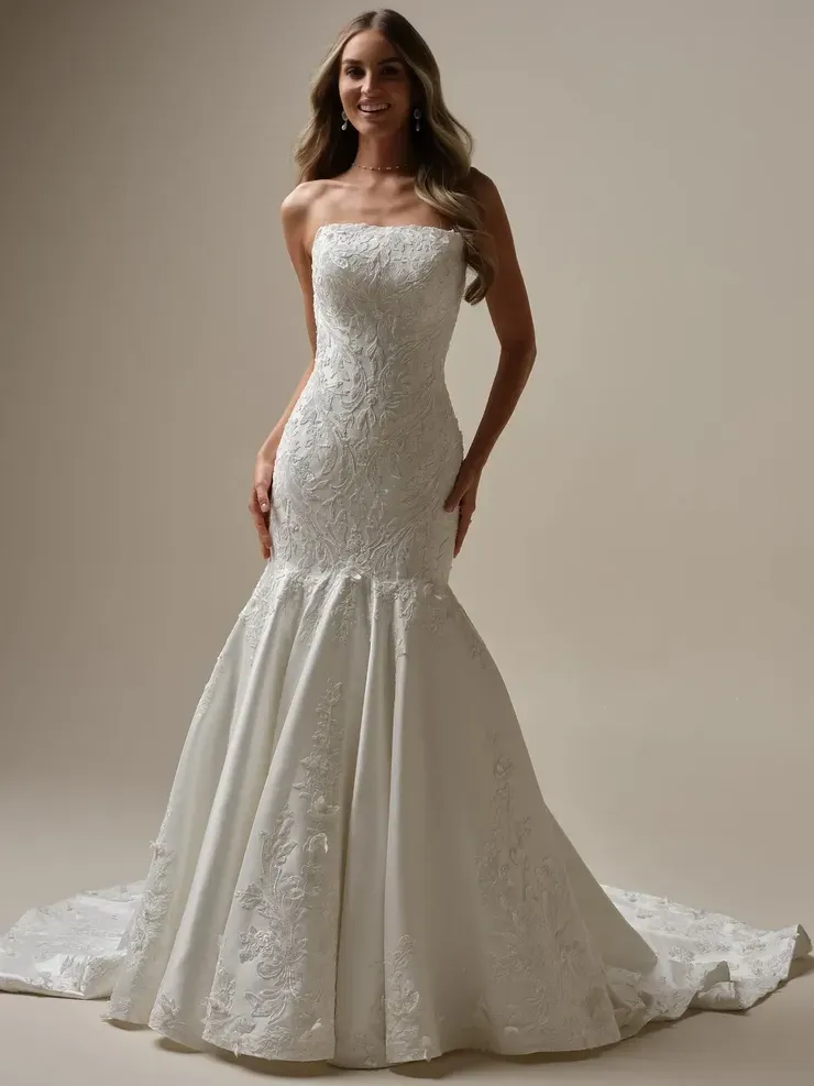 A woman is wearing a white strapless wedding dress.