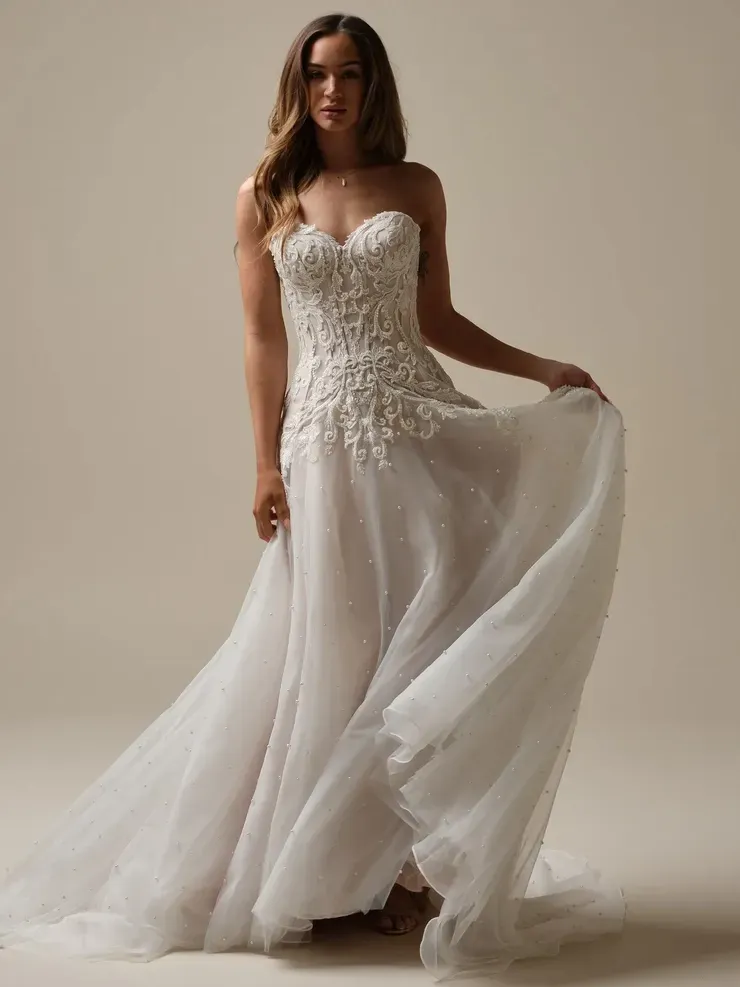 A woman in a white wedding dress is standing on a white background.