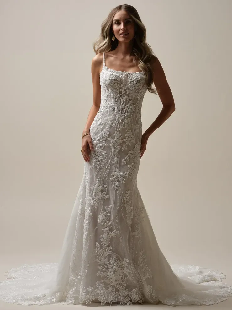 A woman is wearing a white lace wedding dress.