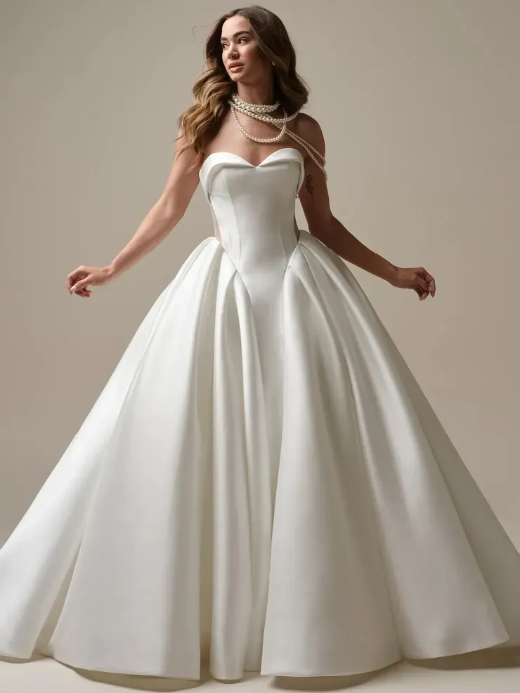 A woman is wearing a white wedding dress with pearls around her neck.