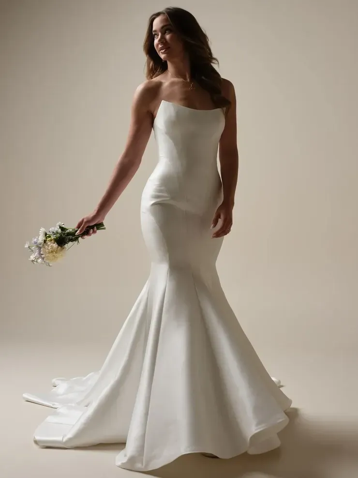 A woman in a white wedding dress is holding a bouquet of flowers.