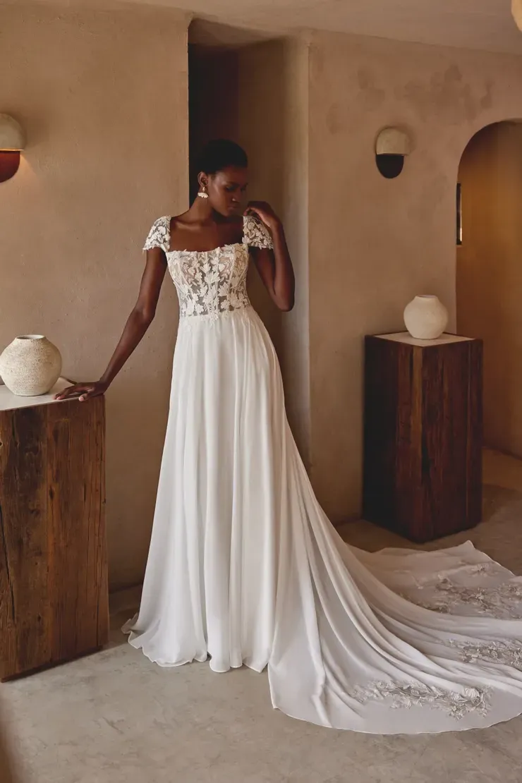 A woman in a white wedding dress is standing in a room.
