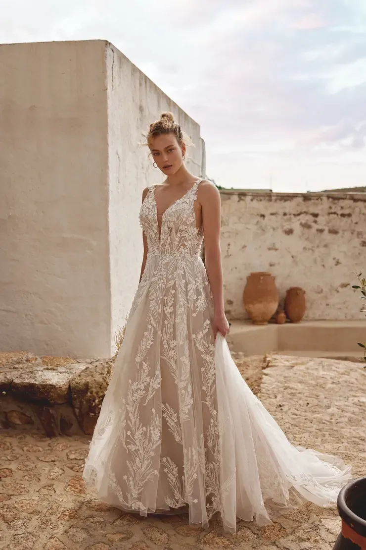 A woman in a wedding dress is standing in front of a building.
