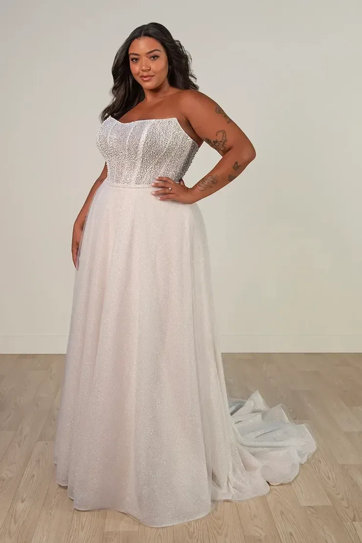 A plus size model is wearing a white wedding dress.