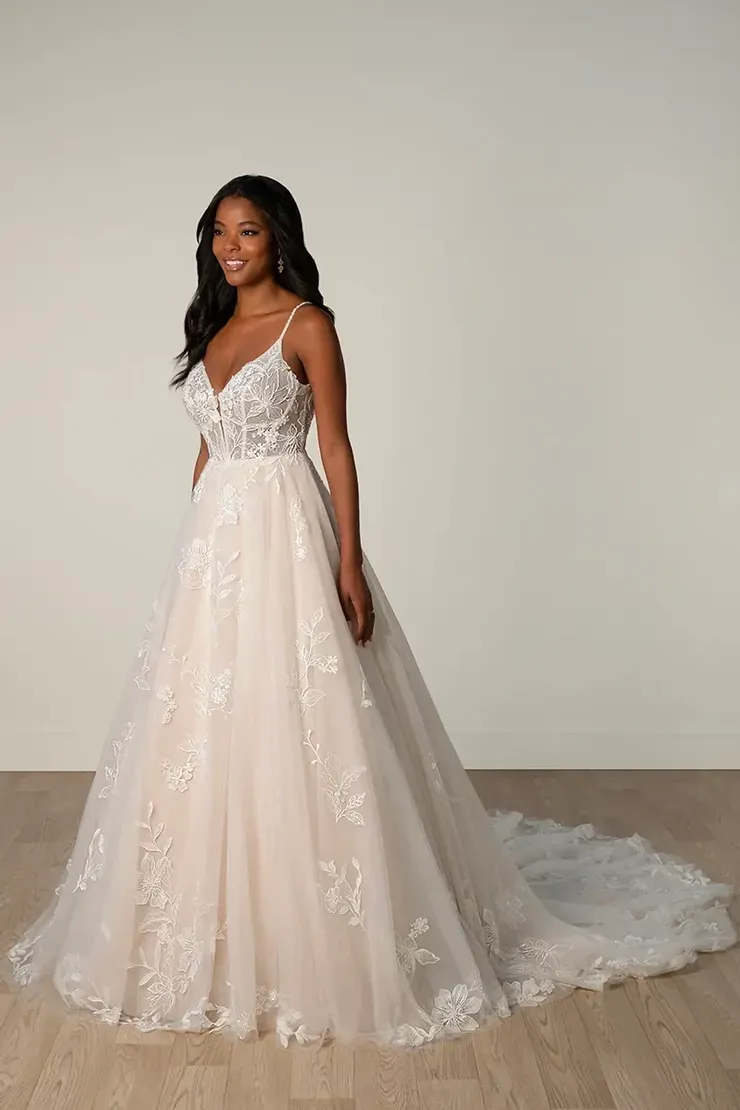 A woman in a wedding dress is standing on a wooden floor.