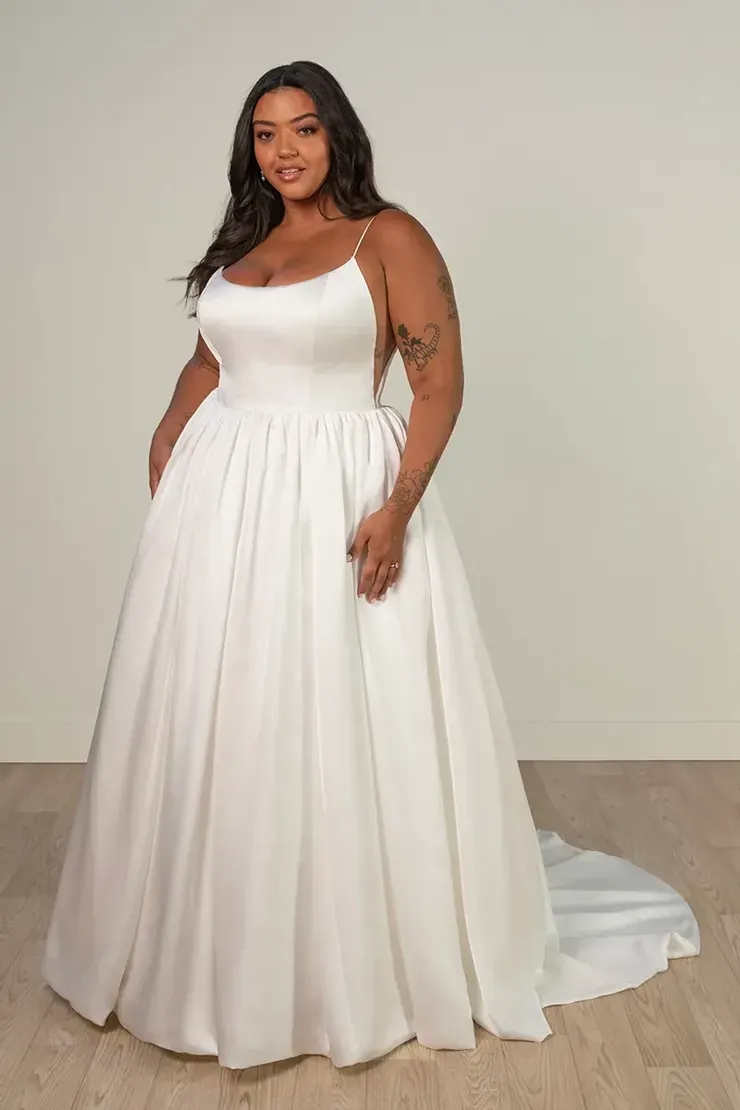 A plus size model is wearing a white wedding dress.