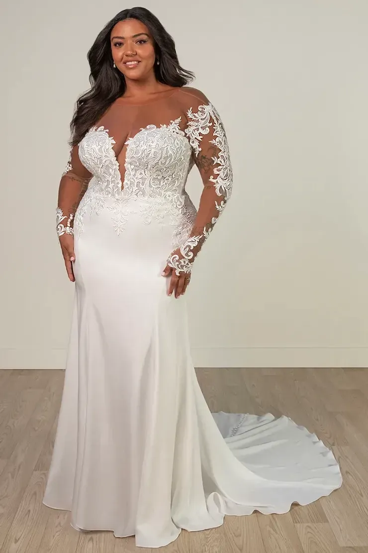 A plus size model is wearing a white wedding dress with long sleeves.