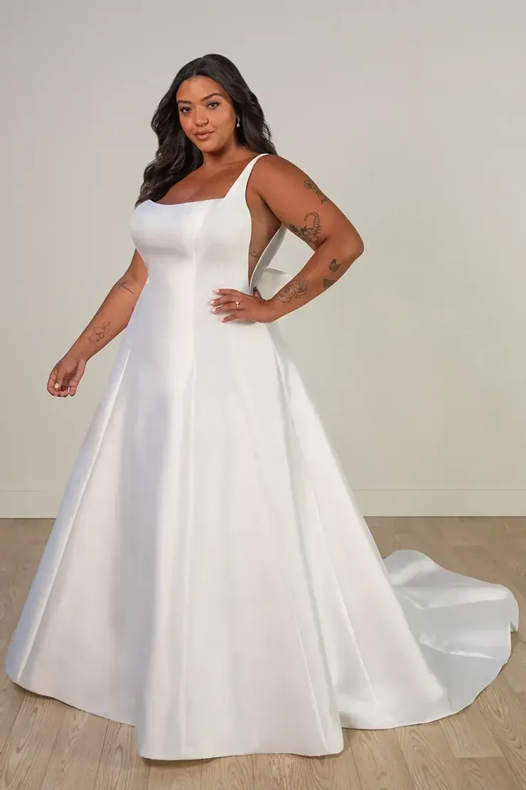 A plus size model is wearing a white wedding dress.