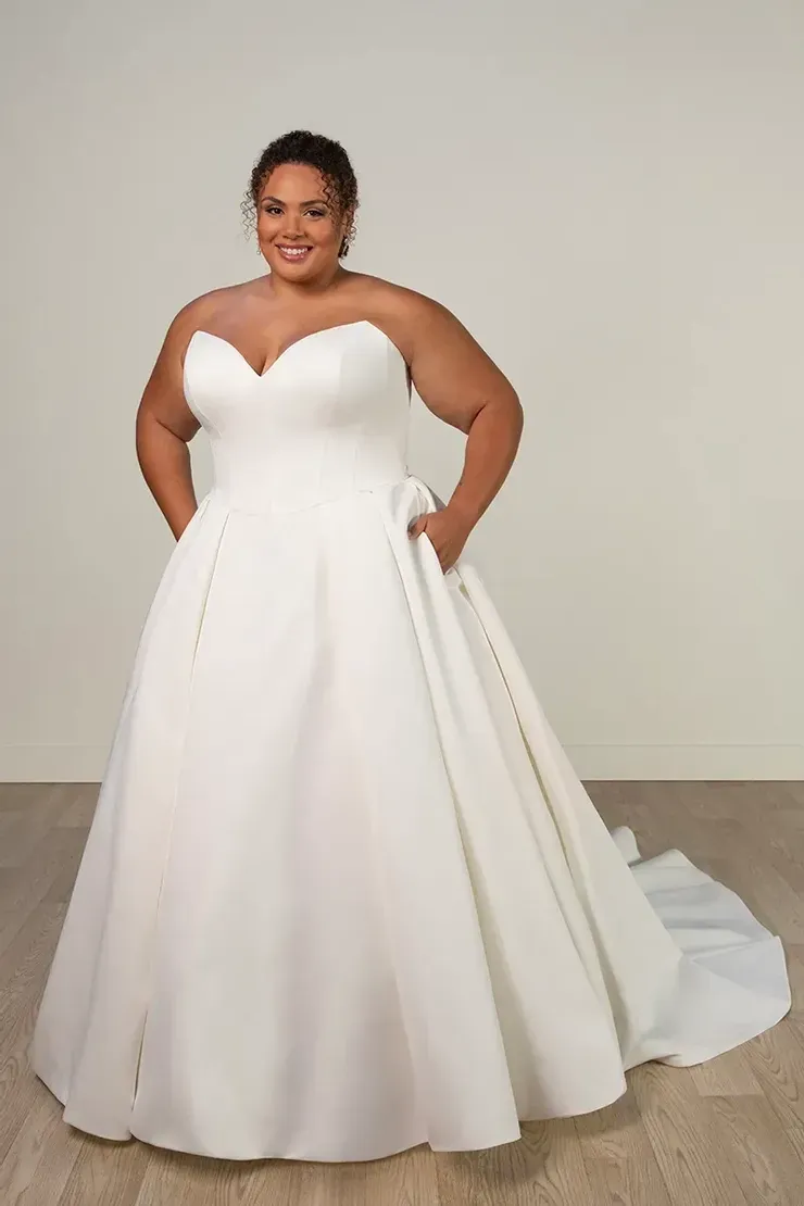 A plus size woman is wearing a white wedding dress.