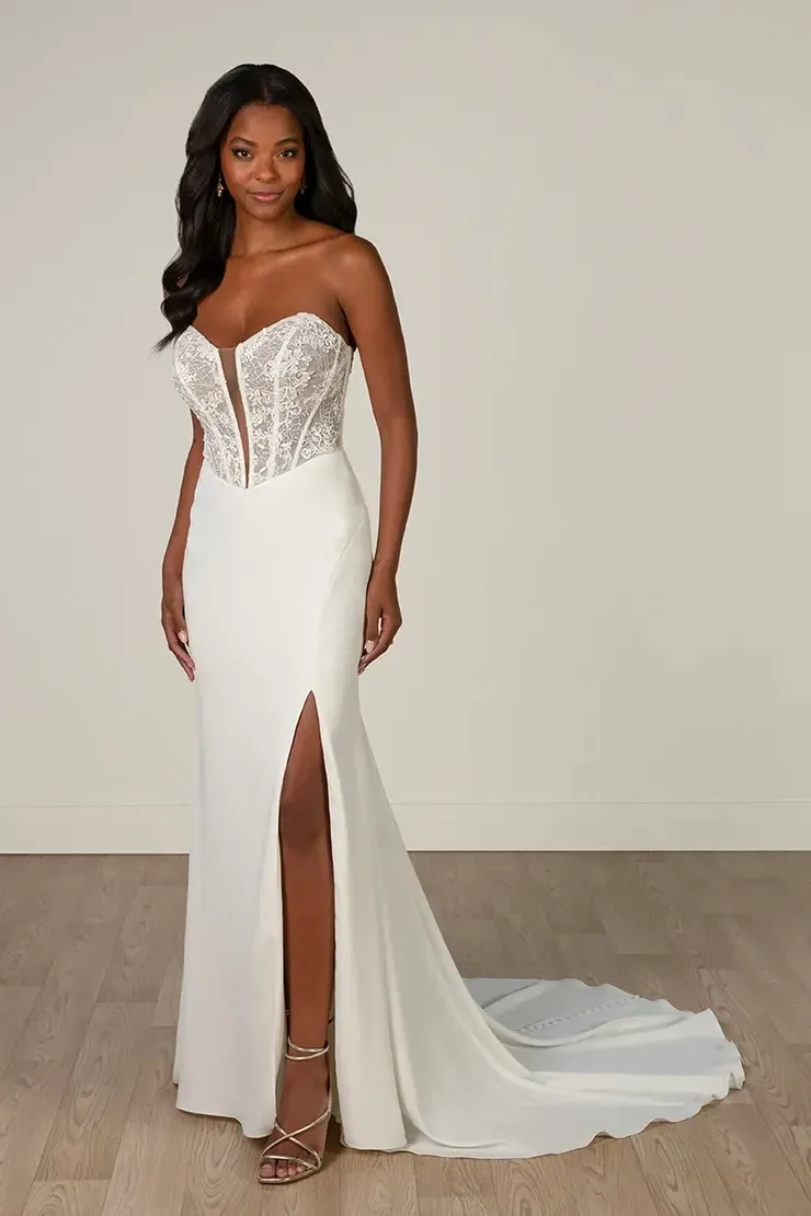 A woman is wearing a white wedding dress with a high slit.