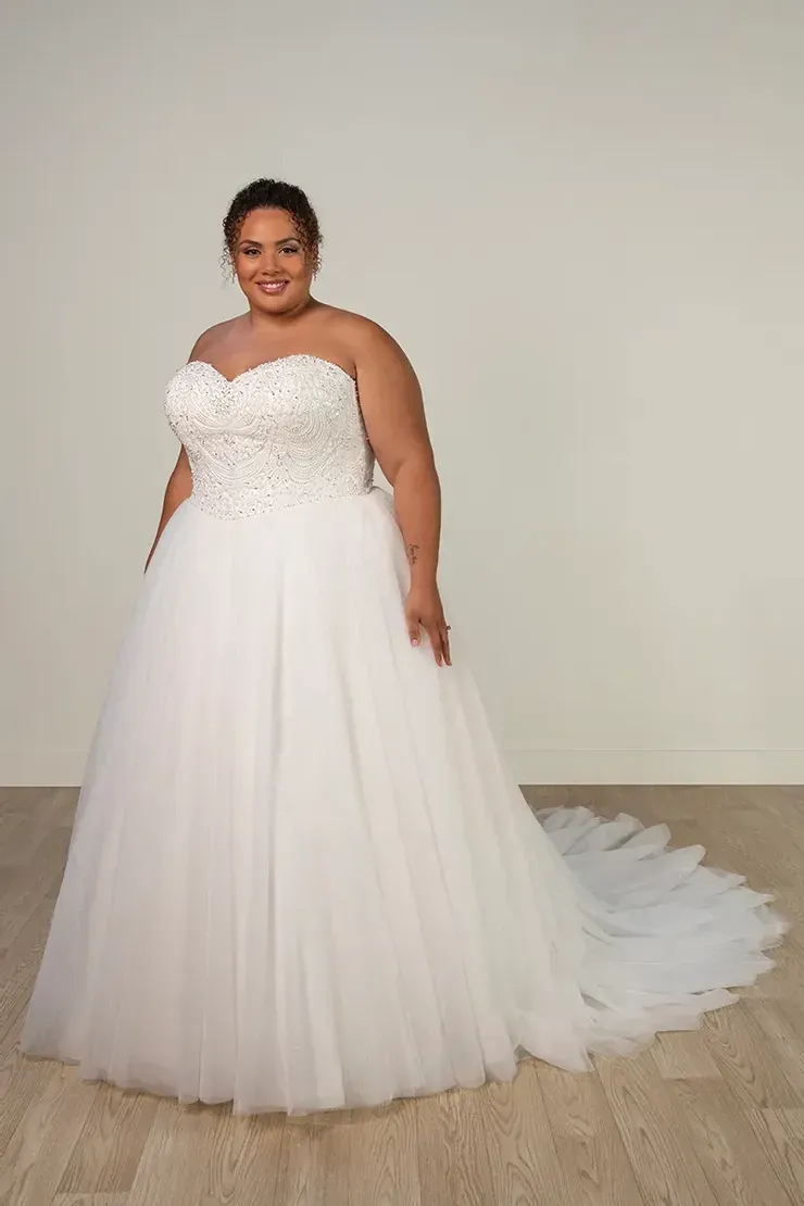 A plus size woman is wearing a white wedding dress.