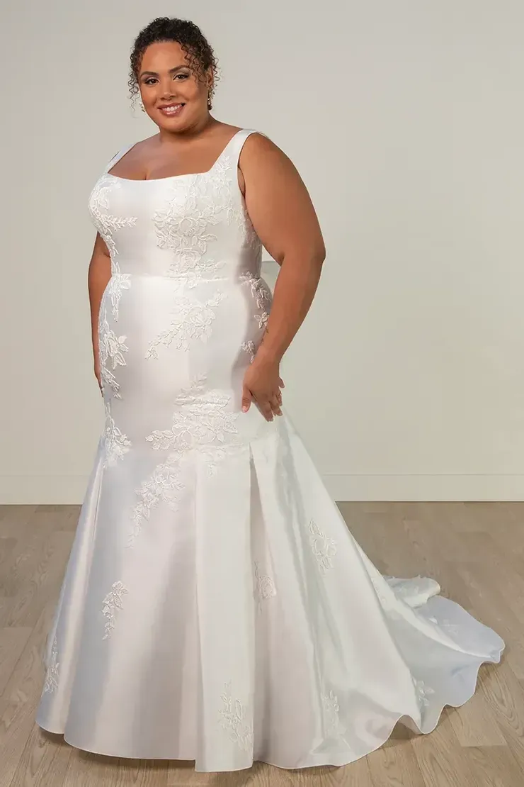 A plus size woman is wearing a white wedding dress.