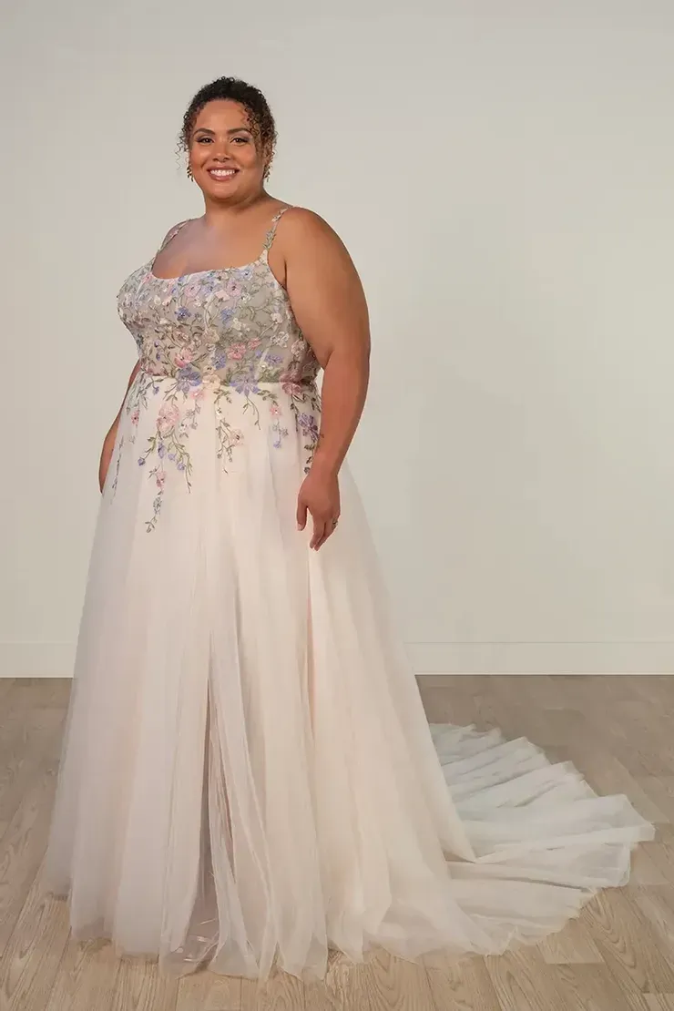 A plus size model is wearing a white wedding dress.