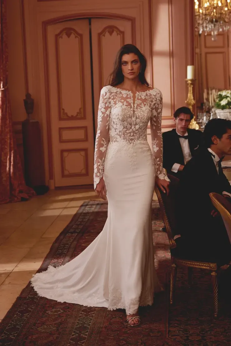 A woman in a white wedding dress is standing in a room.
