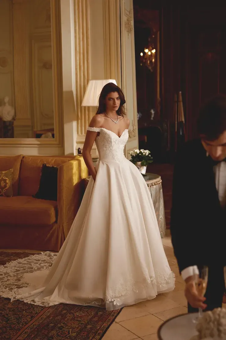 A woman in a wedding dress is standing next to a man in a tuxedo.