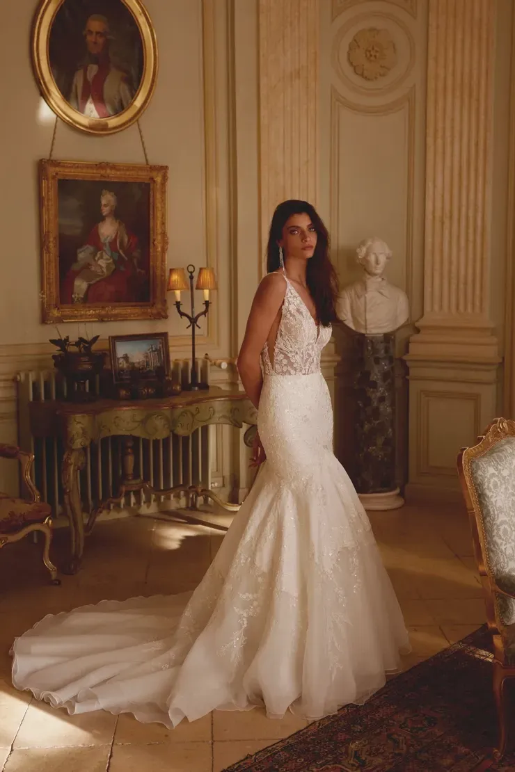 A woman in a wedding dress is standing in a room.
