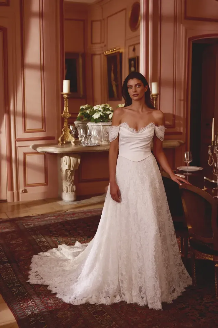 A woman in a white wedding dress is standing in a room.