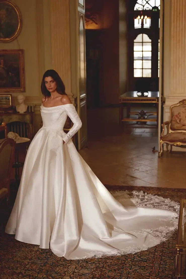 A woman in a white wedding dress is standing in a room.