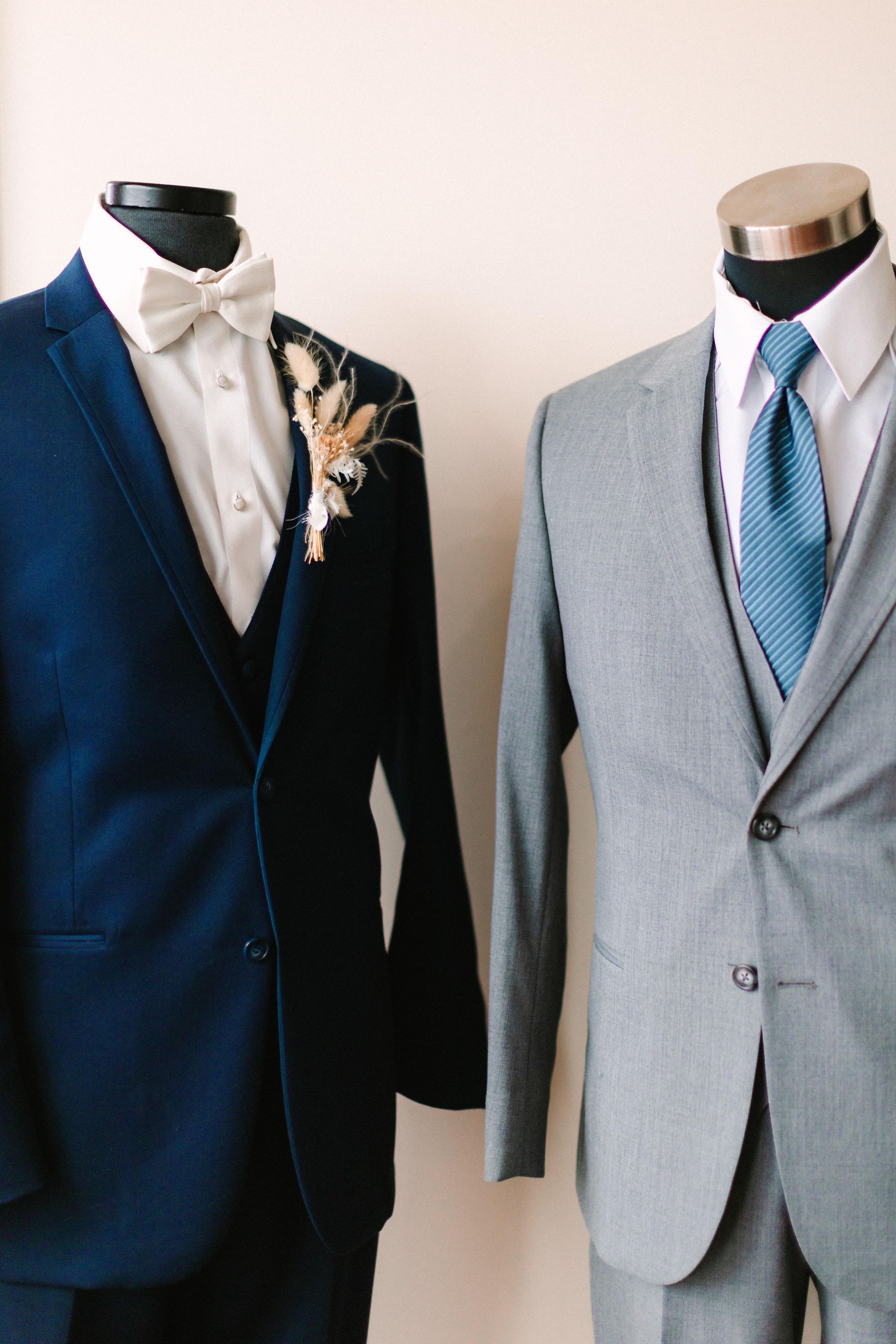 Two men in suits are standing next to each other on a mannequin.