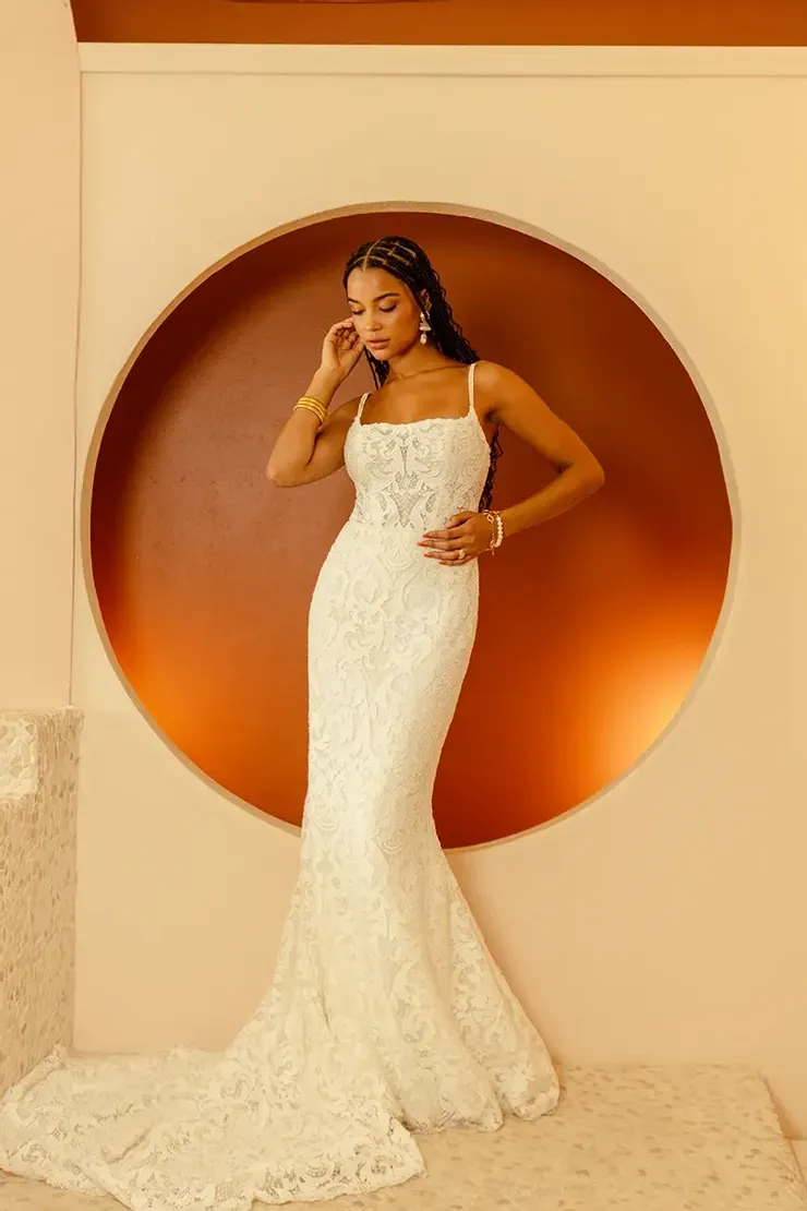 A woman in a white wedding dress is standing in front of a circle.