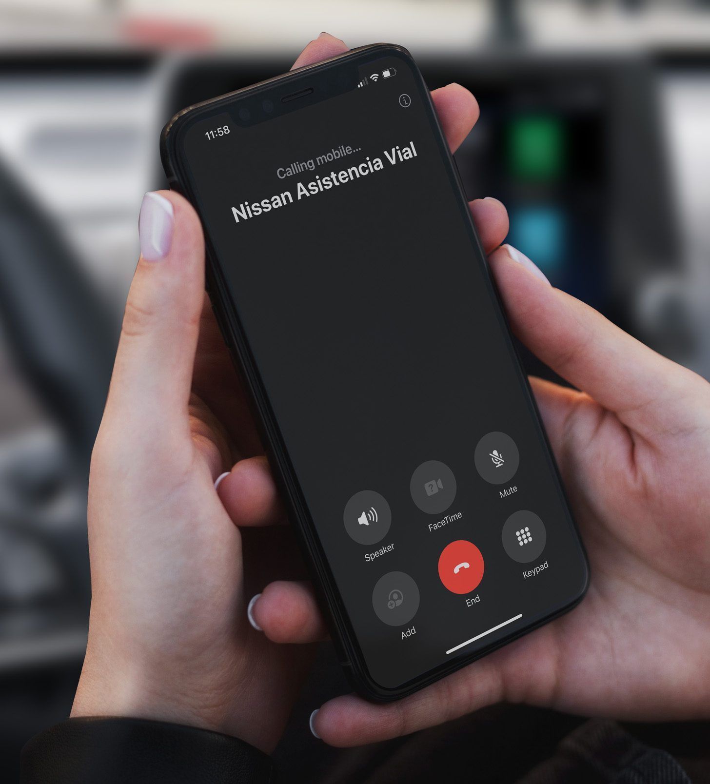 Primer plano de una mano sosteniendo un teléfono que muestra la pantalla de una llamada entrante de "Megan Naismith".