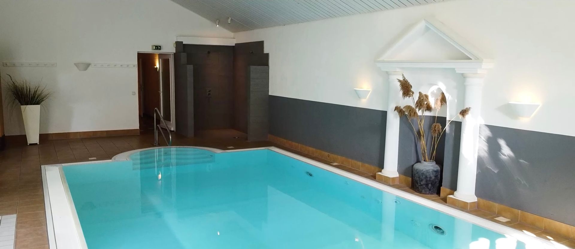 In der Mitte des Raumes befindet sich ein großes Hallenbad.