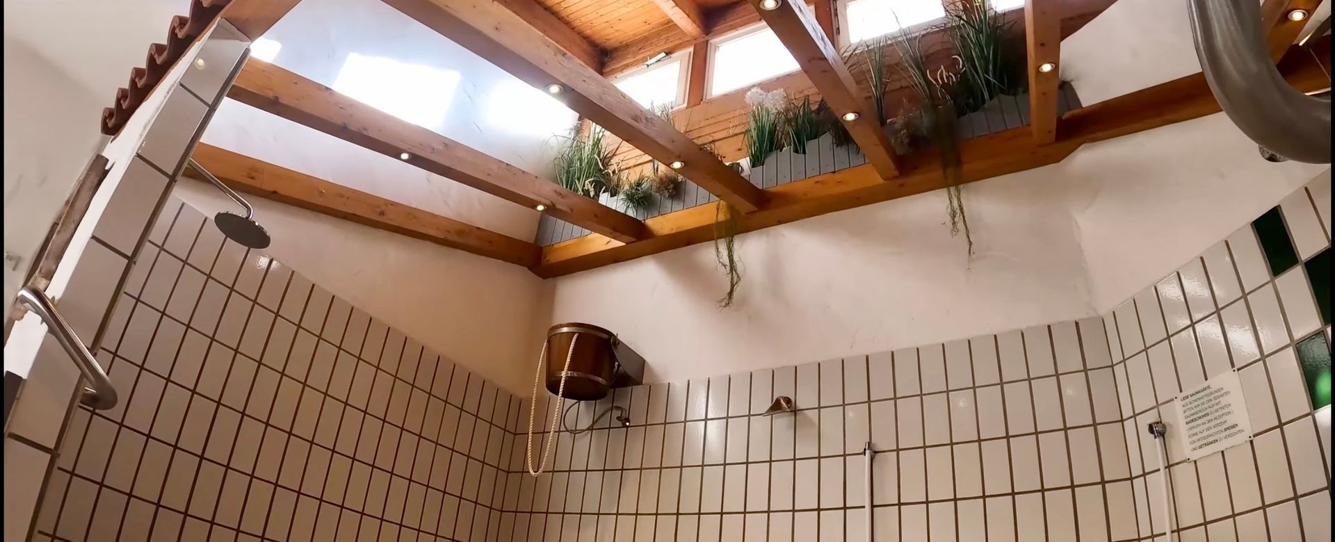 Ein Badezimmer mit Dusche und Holzdecke.