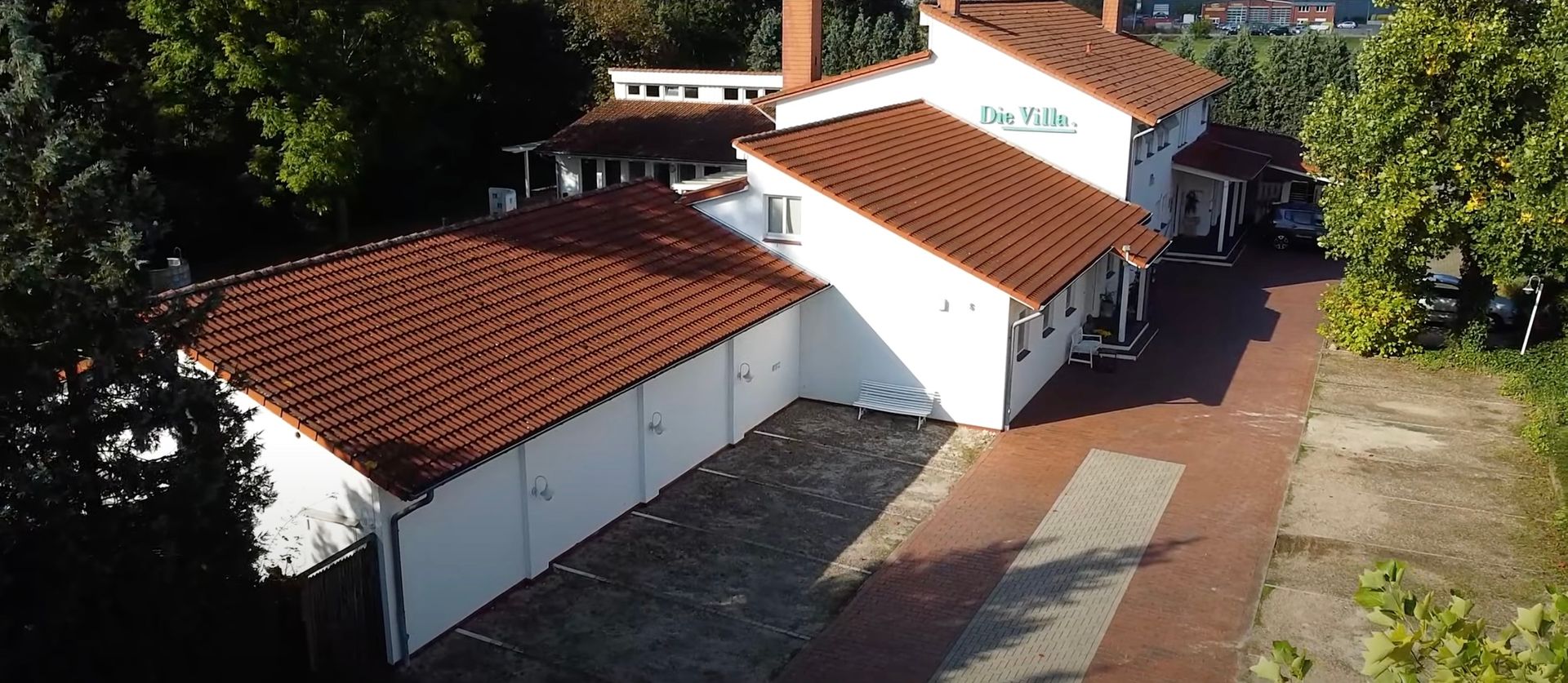Eine Luftaufnahme eines weißen Hauses mit einem roten Ziegeldach
