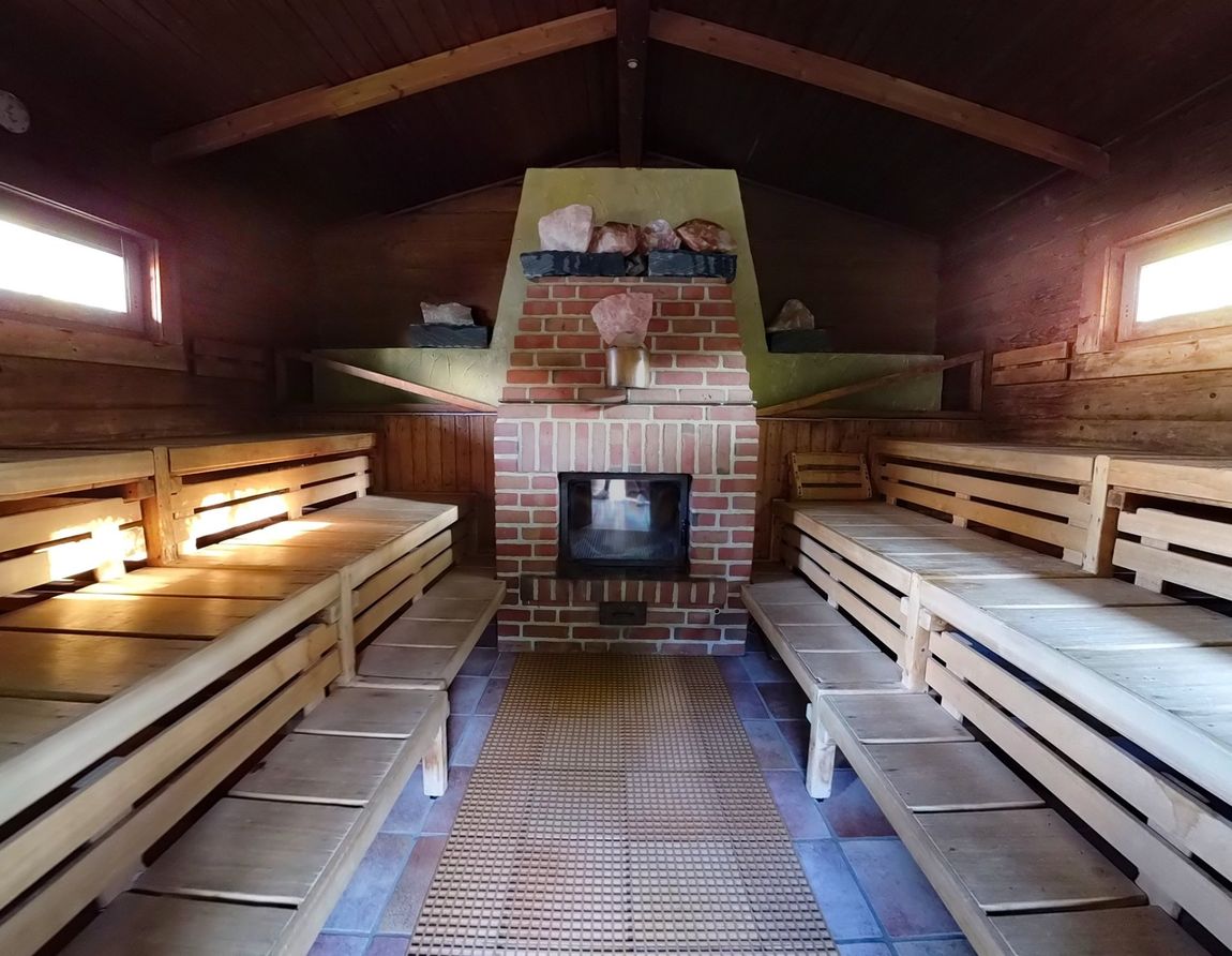 Eine Sauna mit gemauertem Kamin und Holzbänken