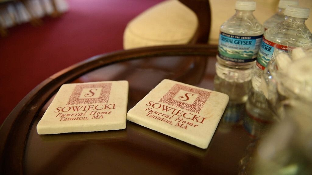 two coasters are sitting on a table next to water bottles .