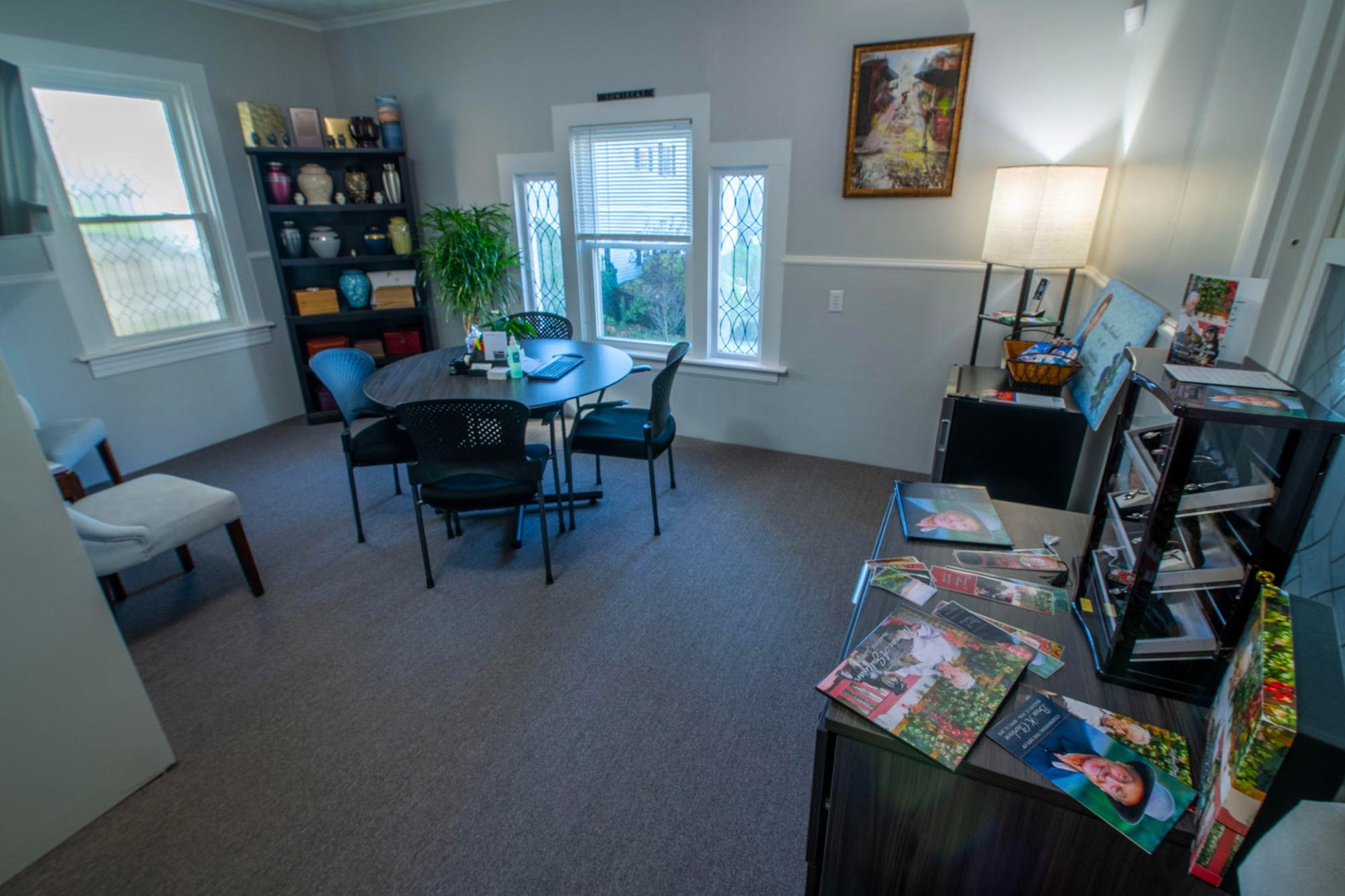 arrangement office with table and chairs. With shelf of urn and nook with remembrance merchandise. 