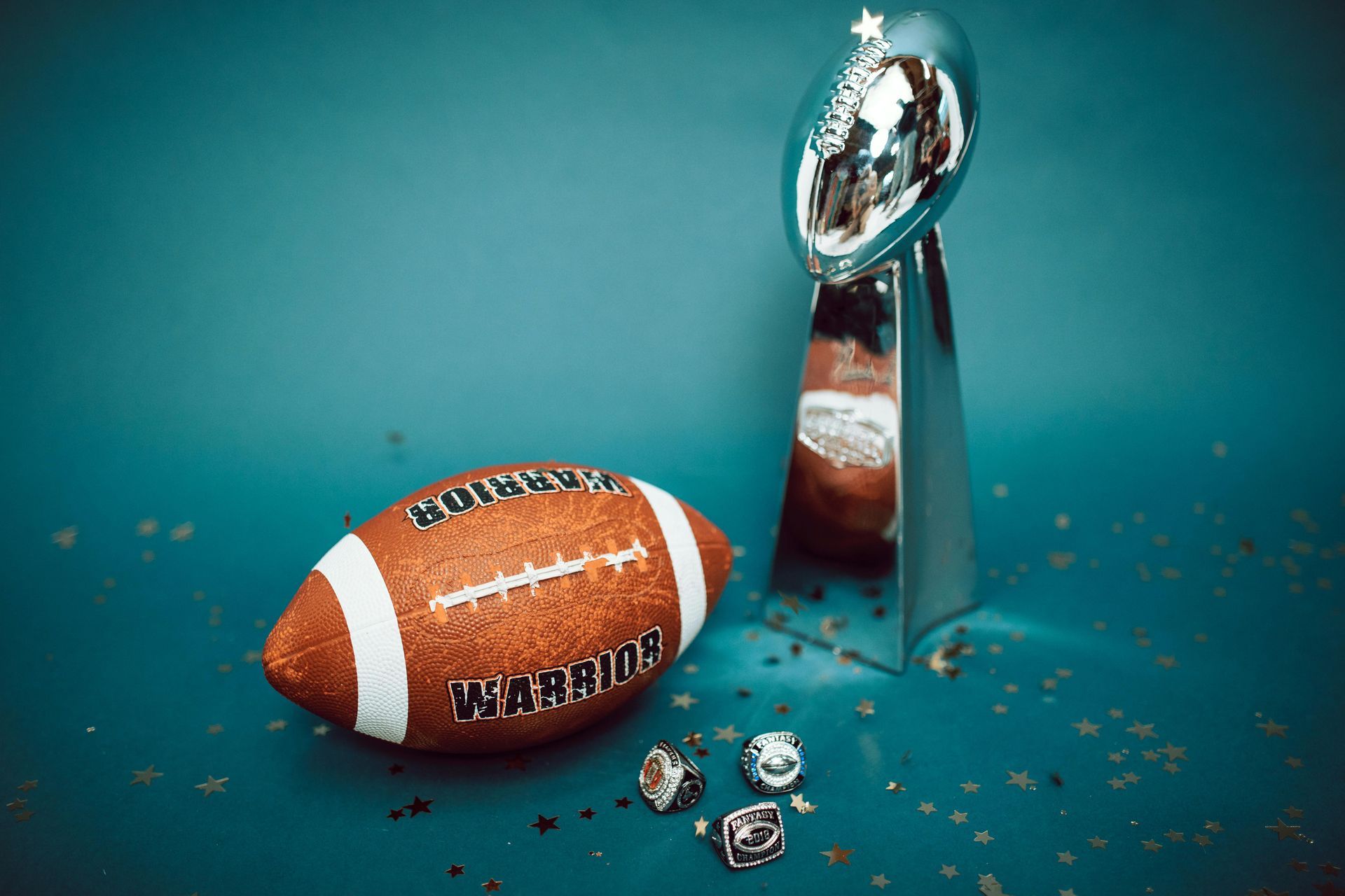 A football and a Super Bowl Trophy on a blue background.