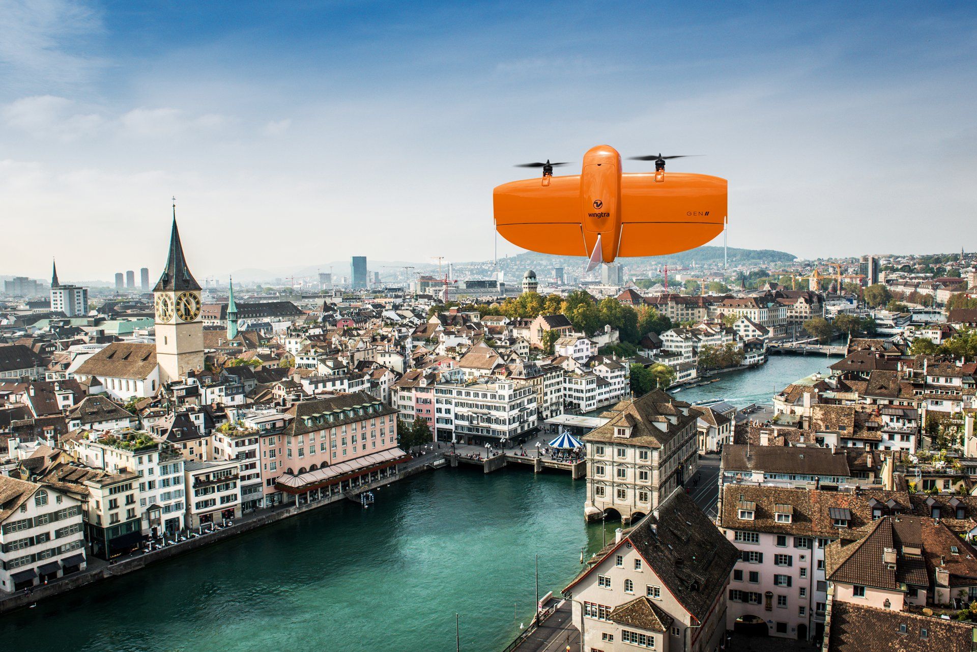 Eine Drohne fliegt über eine Stadt mit einem Fluss im Hintergrund.