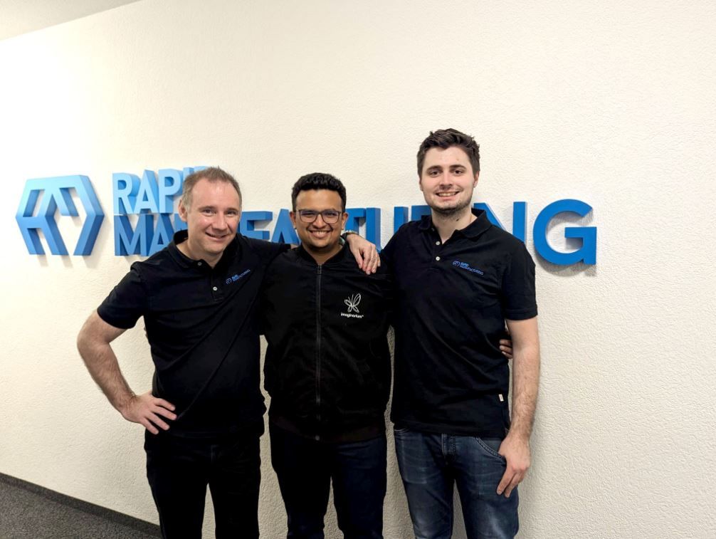 Drei Männer posieren für ein Foto vor einem Schild mit der Aufschrift „Rapid Marketing“