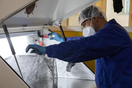 Mann bedient 3D-Drucker mit SLS Technologie