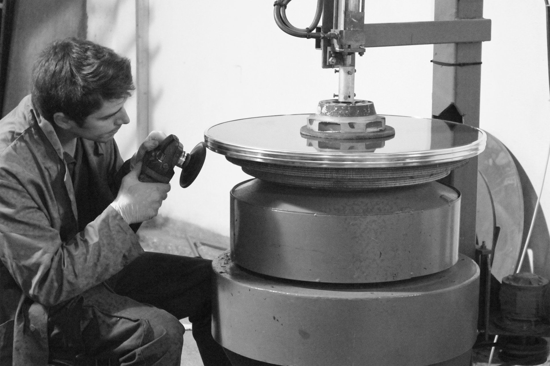 Ein Schwarzweissfoto eines Mannes, der an einer Maschine arbeitet