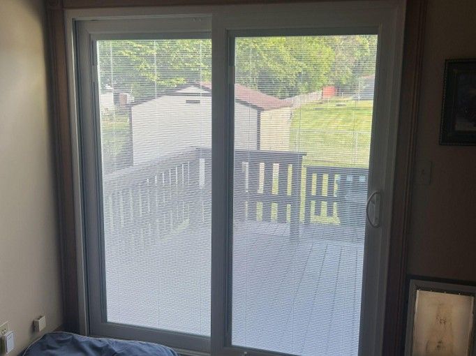 Sliding glass door with a view of a deck and yard outside