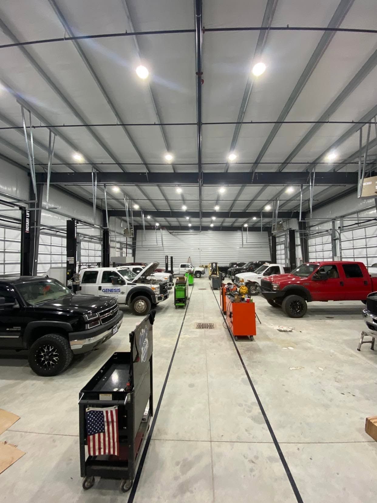 Wide indoor auto showroom with trucks | Drew's Diesel Repair
