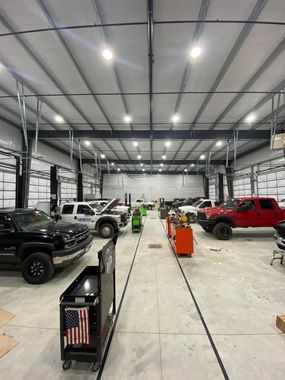 Large indoor vehicle showroom with vehicles | Drew's Diesel Repair