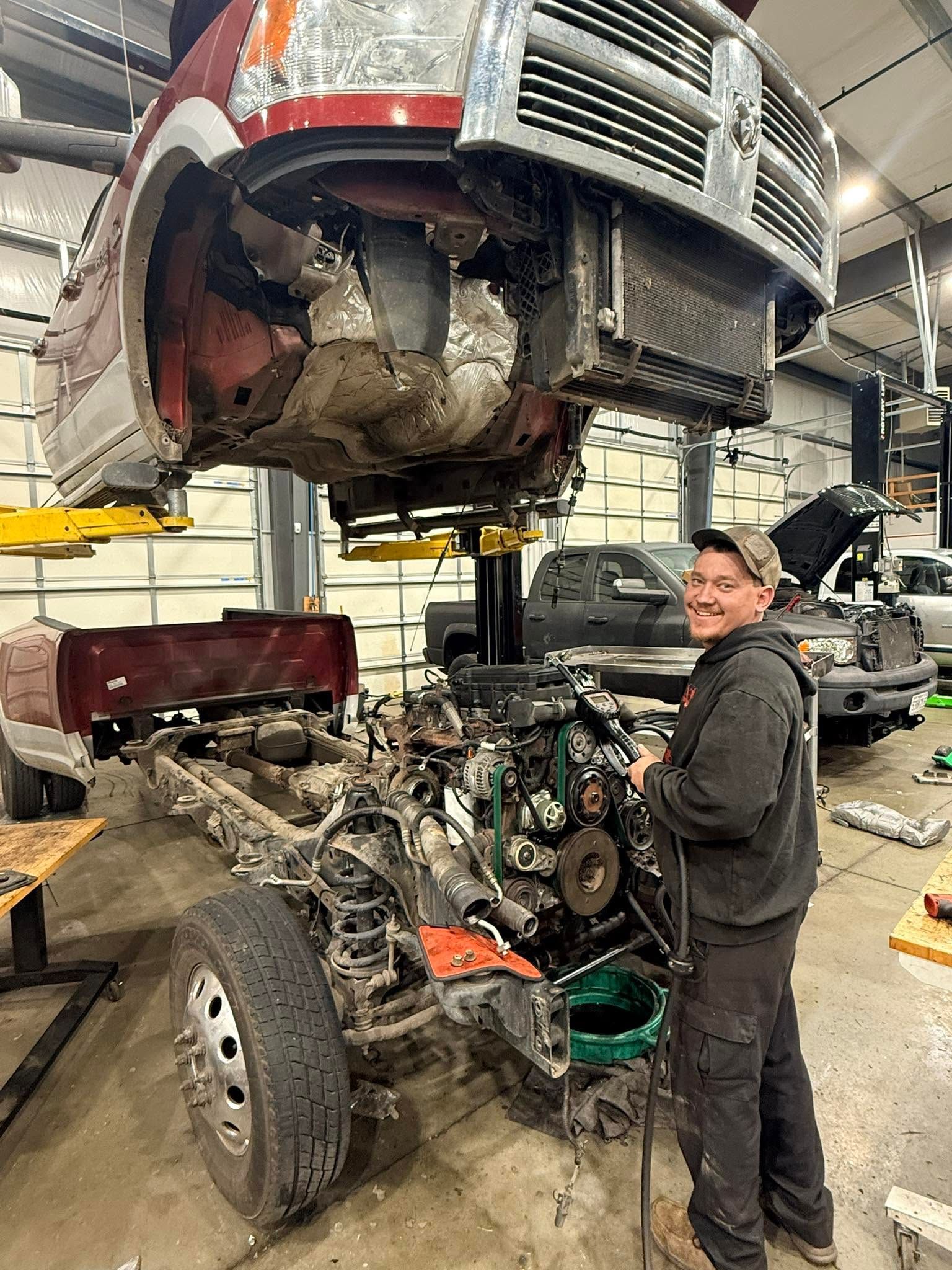 Mechanic standing beside a  car in an auto repair shop | Drews Diesel Drew's
