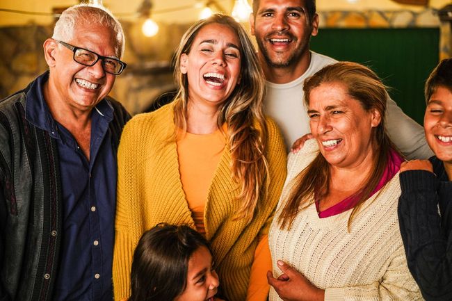 Smiling group of people posing together indoors under warm lights