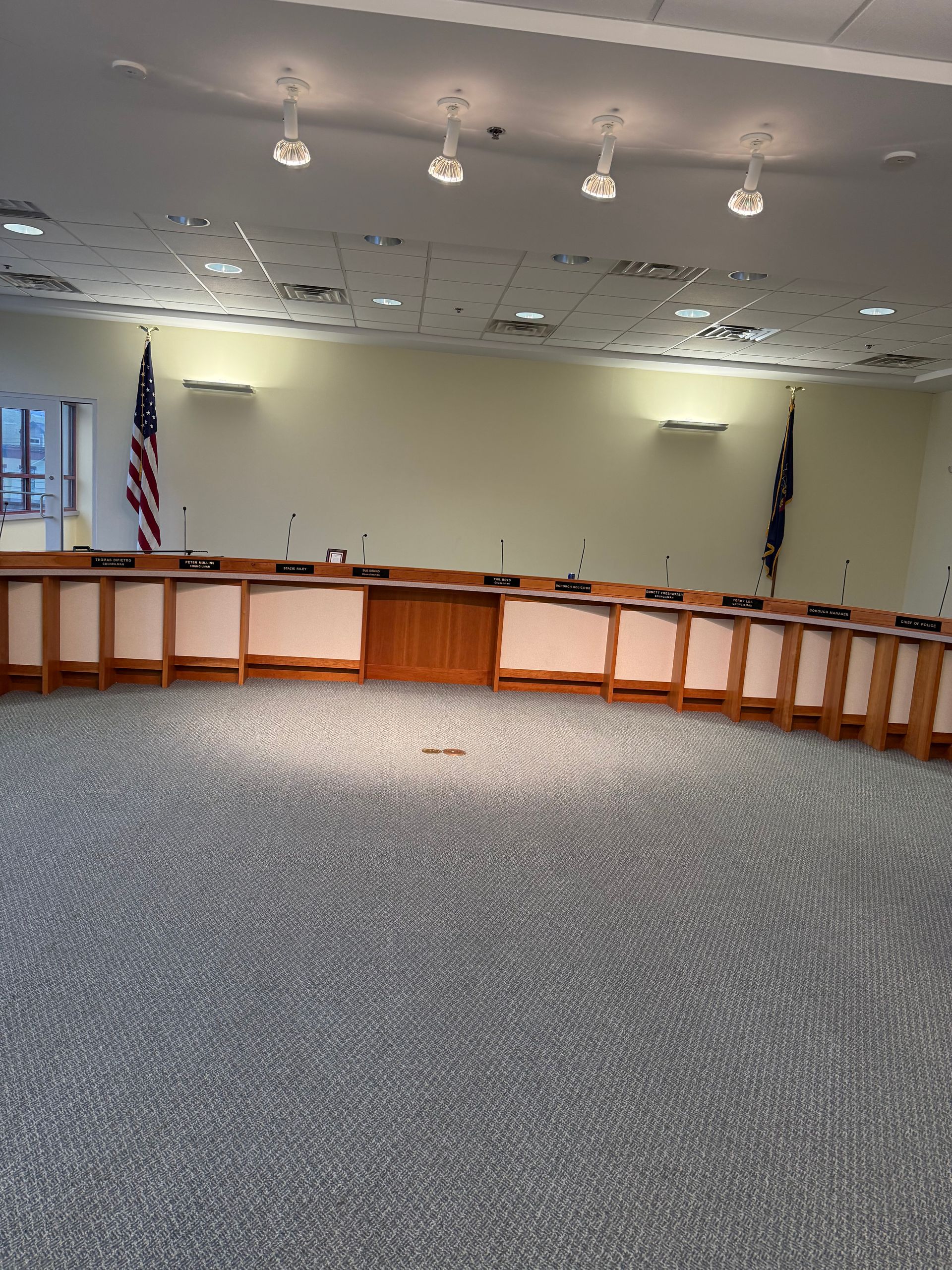 Hand using upholstery cleaner on a teal couch, cleaning its surface.