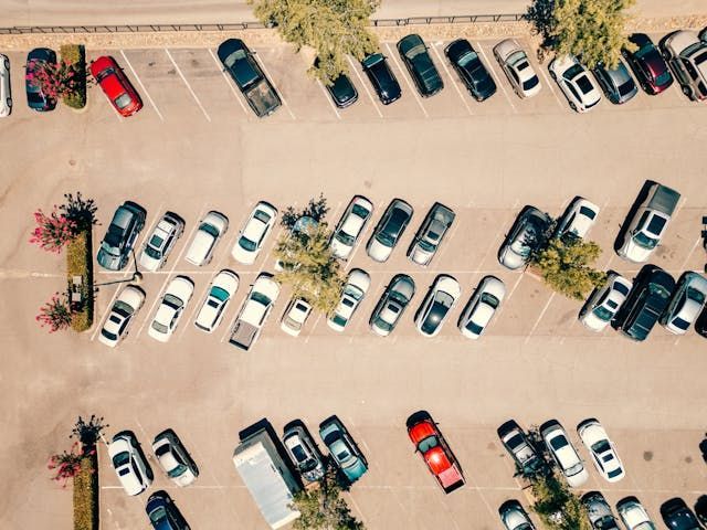 aerial shot of a parking lot filled with cars on a sunny day