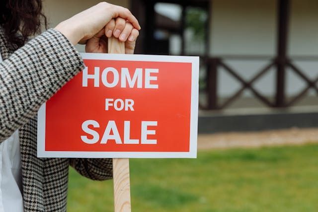 agent+putting+a+home+for+sale+sign+in+ground