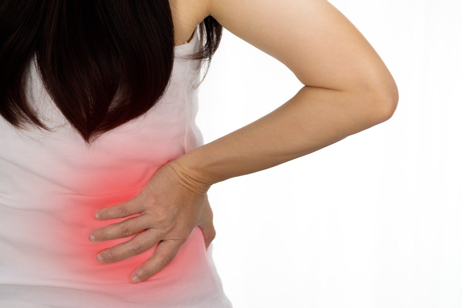 A woman is holding her back in pain with a red spot on her back