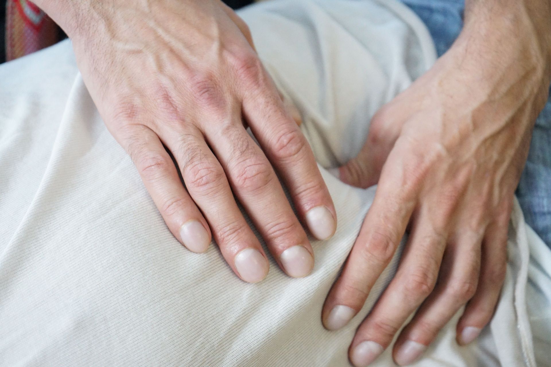 Hands resting on a person’s leg, suggesting comfort or care
