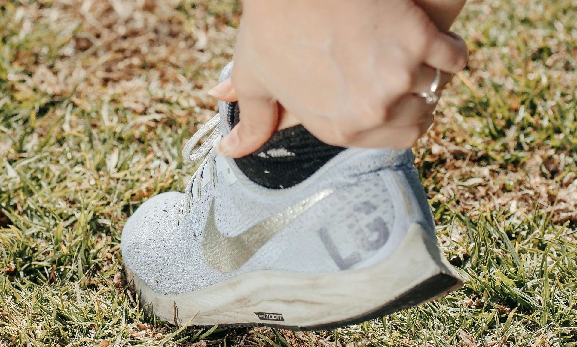 A person holding their painful ankle.